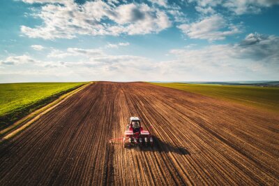 Agriculteur avec tracteur ensemencement des cultures au champ, vue aérienne
