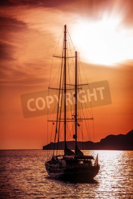 Papier peint  Ancien navire naviguant vers le coucher du soleil. Vue spectaculaire sur la mer