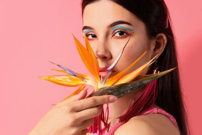 Papier peint  Beautiful young woman with strelitzia flower on color background