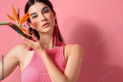 Papier peint  Beautiful young woman with strelitzia flower on color background