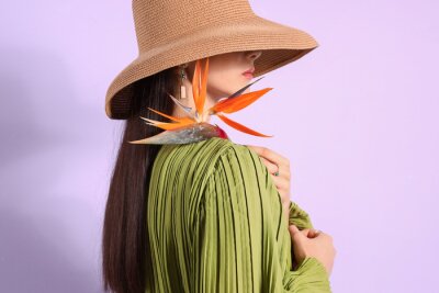 Papier peint  Beautiful young woman with strelitzia flower on color background