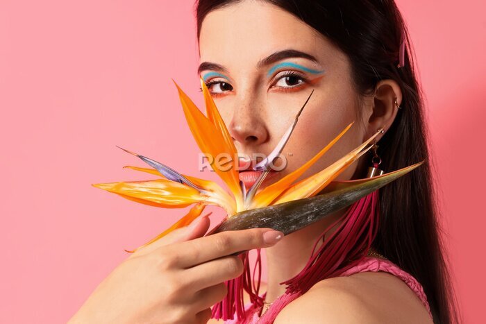 Papier peint  Beautiful young woman with strelitzia flower on color background