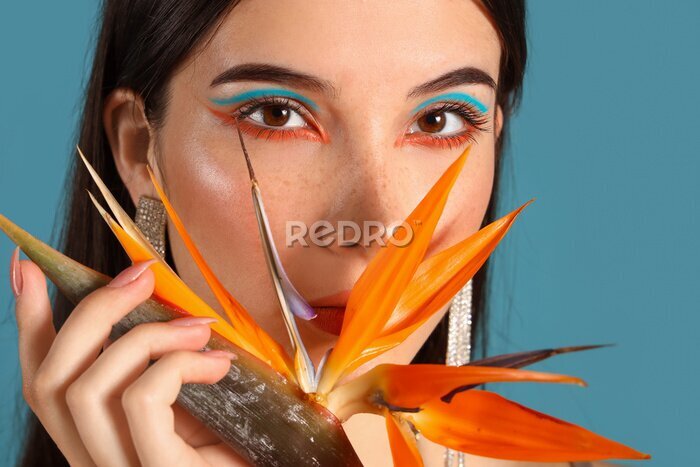 Papier peint  Beautiful young woman with strelitzia flower on color background