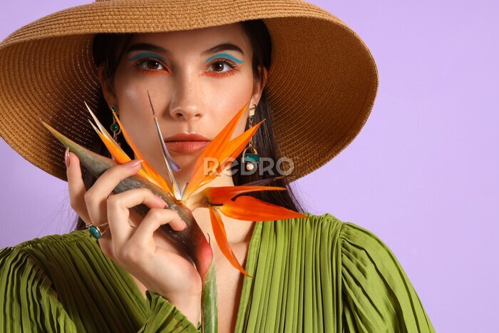 Papier peint  Beautiful young woman with strelitzia flower on color background