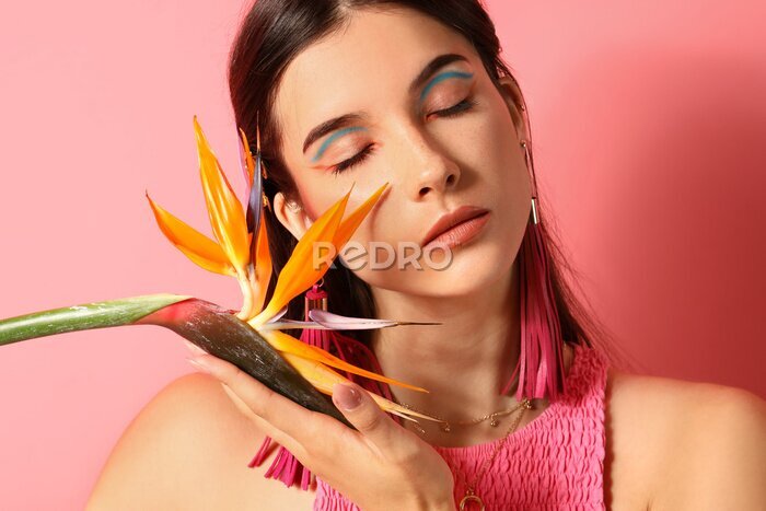 Papier peint  Beautiful young woman with strelitzia flower on color background