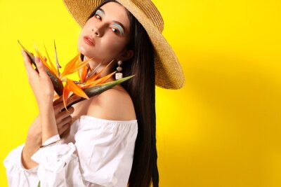 Papier peint  Beautiful young woman with strelitzia flowers on color background