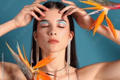 Papier peint  Beautiful young woman with strelitzia flowers on color background