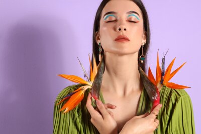 Papier peint  Beautiful young woman with strelitzia flowers on color background