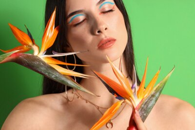 Papier peint  Beautiful young woman with strelitzia flowers on color background