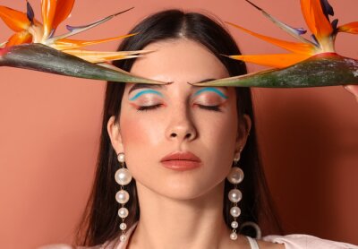 Papier peint  Beautiful young woman with strelitzia flowers on color background