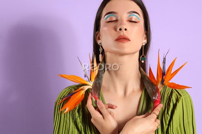Papier peint  Beautiful young woman with strelitzia flowers on color background