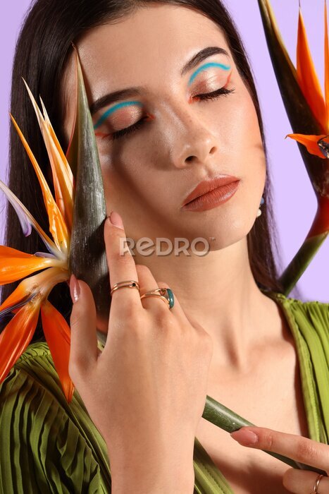 Papier peint  Beautiful young woman with strelitzia flowers on color background
