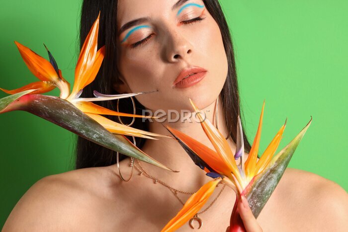 Papier peint  Beautiful young woman with strelitzia flowers on color background