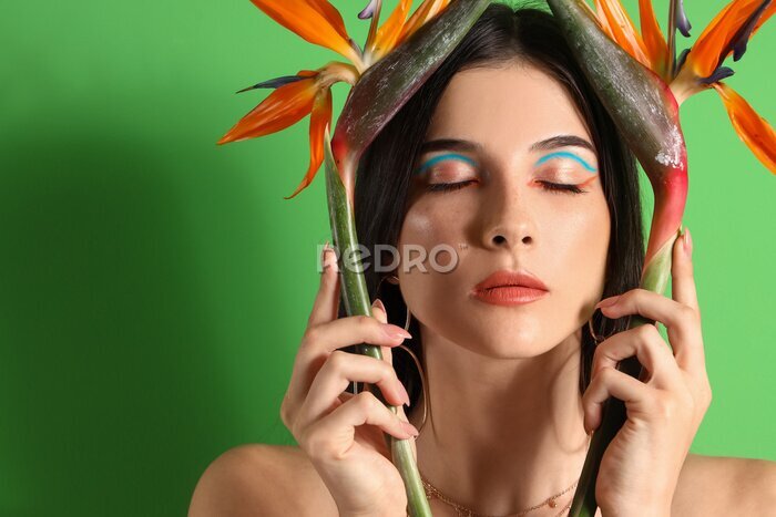 Papier peint  Beautiful young woman with strelitzia flowers on color background