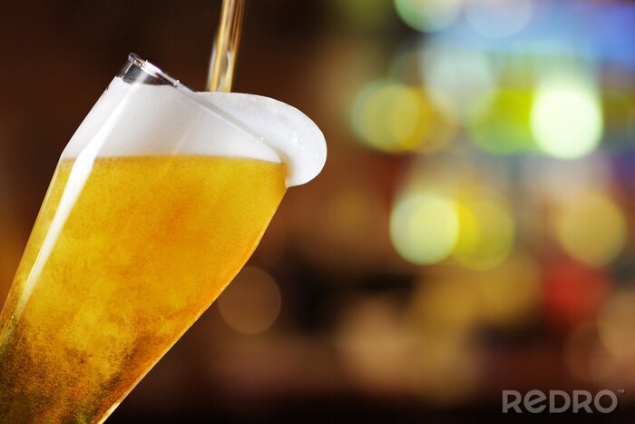 Papier peint  Bière versée dans un verre dans un bar