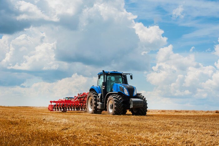 Papier peint  Blue tractor in the field, agricultural machinery work, field and beautiful sky