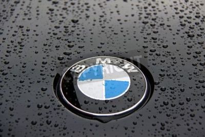 Papier peint  Bonnet et l'insigne d'une BMW Série 1 noir avec des gouttes de pluie