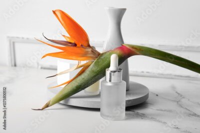 Papier peint  Bottle of cosmetic product with beautiful strelitzia flower and vase on light background