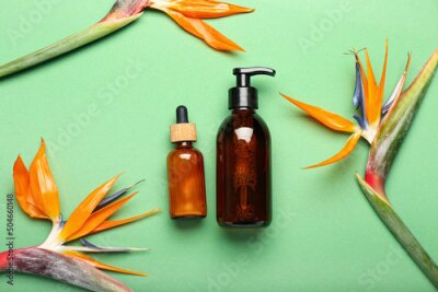 Papier peint  Bottles of cosmetic products and strelitzia flowers on green background