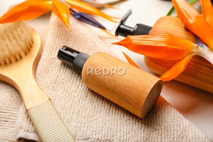 Papier peint  Bottles of cosmetic products and strelitzia flowers on table, closeup