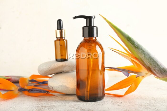Papier peint  Composition with bottles of cosmetic products and strelitzia flowers on light background
