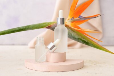 Papier peint  Composition with bottles of essential oil and strelitzia flower on light background