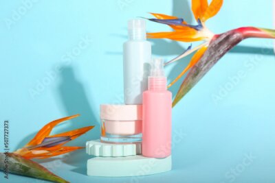 Papier peint  Composition with cosmetic products and strelitzia flowers on blue background