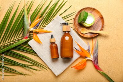 Papier peint  Composition with cosmetic products, strelitzia flowers and palm leaf on color background