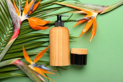 Papier peint  Cosmetic products and strelitzia flowers on green background