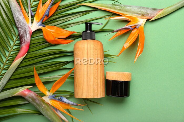 Papier peint  Cosmetic products and strelitzia flowers on green background