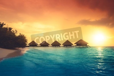 Papier peint  Coucher de soleil derrière des maisons sur la mer