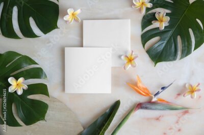 Papier peint  Empty card with envelope on marble table and tropical flowers. Mockup template with top view. Strelitzia, plumeria flowers and monstera leaves on marble floor.
