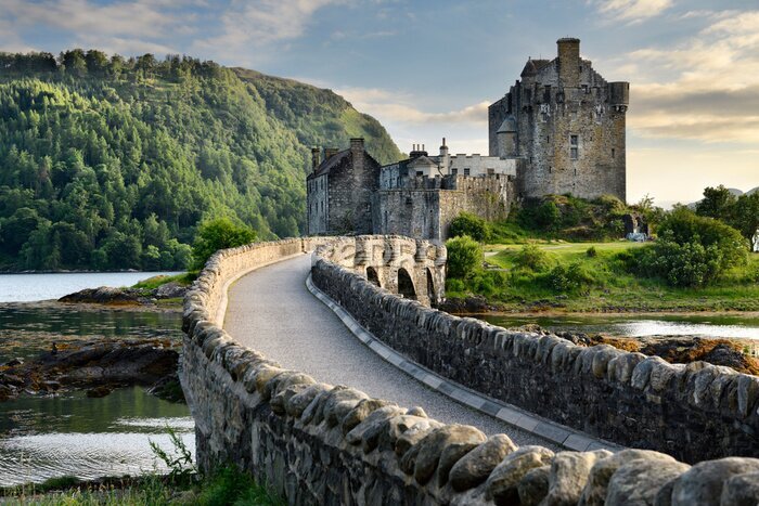 Papier peint  Evening light on restored Eilean Donan Castle on Island at three lochs with added stone arch footbridge Scottish Highlands Scotland UK