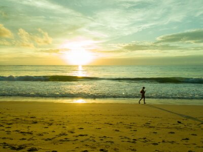 Papier peint  Femme sur la plage au coucher du soleil