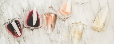 Flat-lay de vin rouge, rose et blanc dans des verres et des tire-bouchons sur fond de marbre gris, vue de dessus, composition large. Bar à vin, établissement vinicole, concept de dégustation de vin