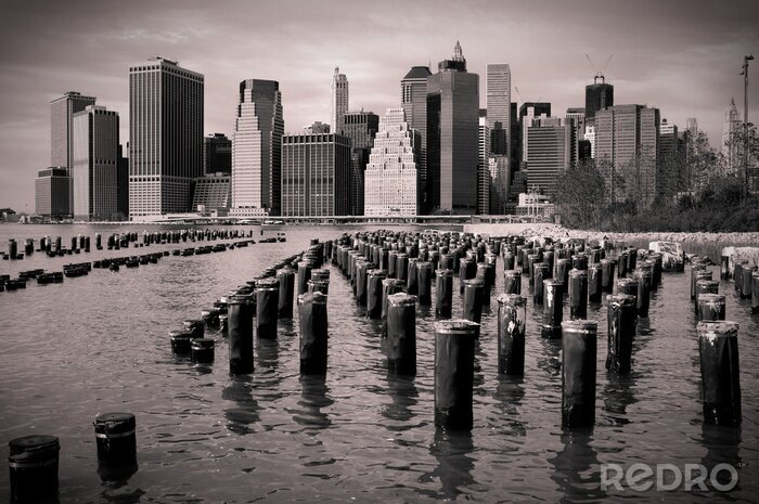 Papier peint  Horizon de Manhattan avec poteaux en bois dans l'eau, noir et blanc