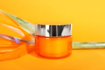 Papier peint  Jar of cosmetic product and strelitzia flower on color background