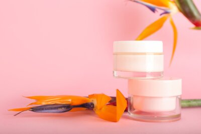 Papier peint  Jars of cosmetic products and strelitzia flowers on pink background