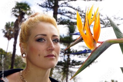 Papier peint  Junge Frau mit Paradiesvogelblume (Strelitzia reginae)