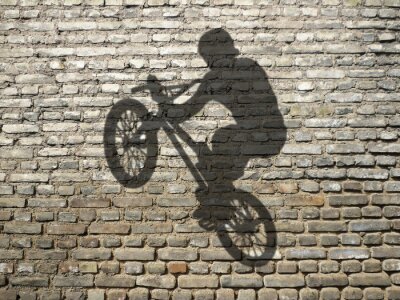 L'ombre d'un cycliste sur un mur