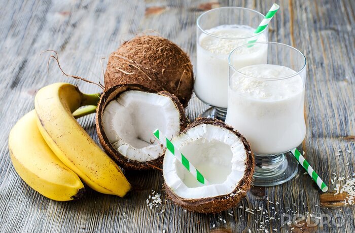 Papier peint  Le lait de coco boisson smoothie avec des bananes sur fond de bois