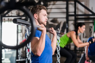 Mann im Fitnessstudio bei Fonctionnel Fitness Sport avec Hantel und Kette