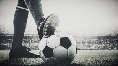 Papier peint  pieds de joueur de football marchent sur le ballon de football pour le coup d'envoi dans le stade noir et blanc
