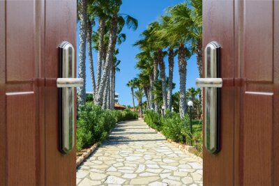 Papier peint  Porte ouverte sur un trottoir bordé de palmiers