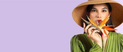 Papier peint  Pretty young woman holding strelitzia flower on lilac background with space for text