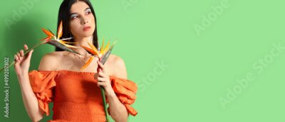 Papier peint  Pretty young woman holding strelitzia flowers on green background with space for text