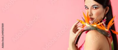 Papier peint  Pretty young woman holding strelitzia flowers on pink background with space for text