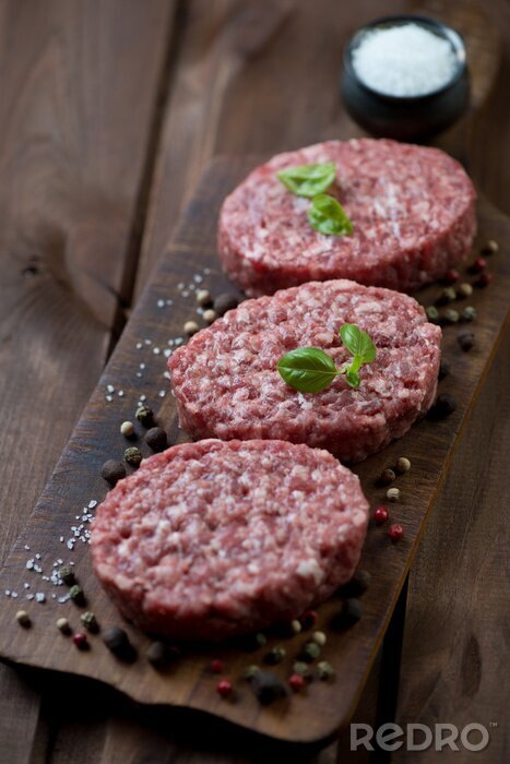 Papier peint  Raw beef cutlets with various spices, rustic wooden background