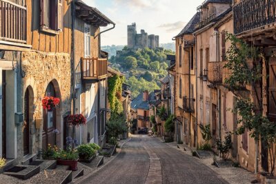 Papier peint  Rue dans un village français avec vue sur un château