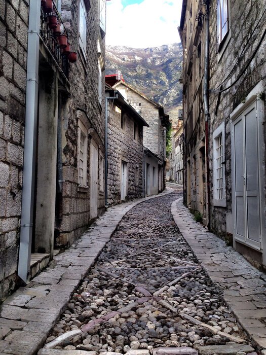 Papier peint  Ruelle sombre sur fond de montagnes